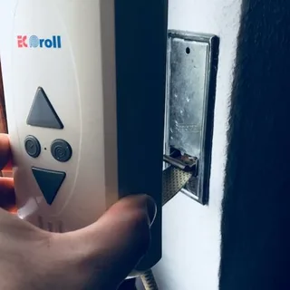 Elektrischer Gurtwickler wird mit dem Schraubendreher an der Wand montiert
