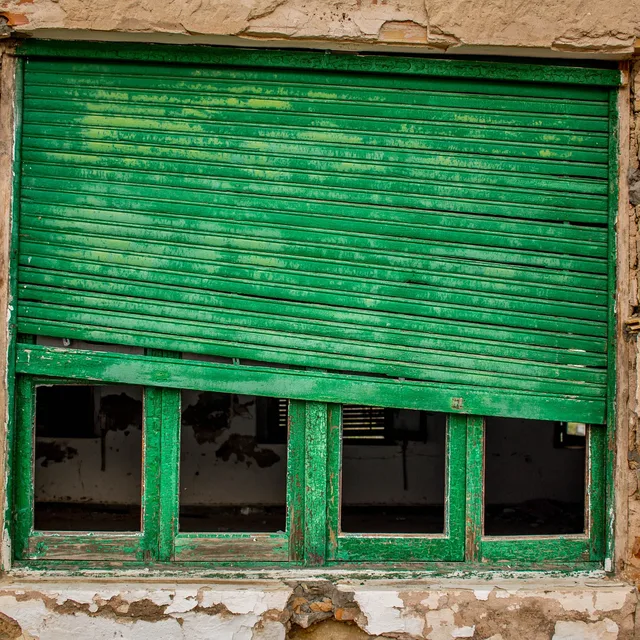 Offenes Fenster mit heruntergelassenem Rollladen